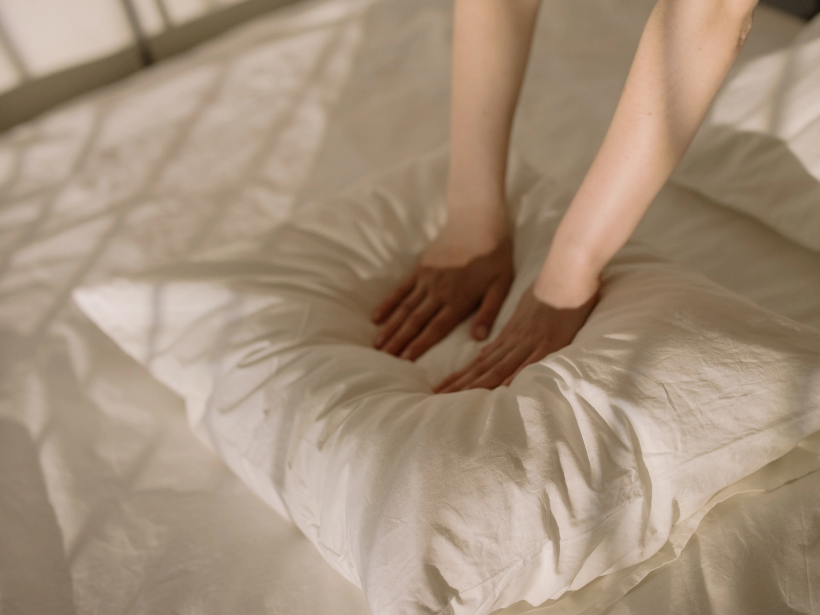 hands flattening a pillow